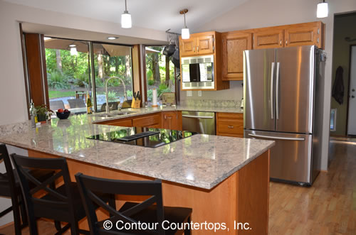 A kitchen with granite counter tops and stainless steel appliances.