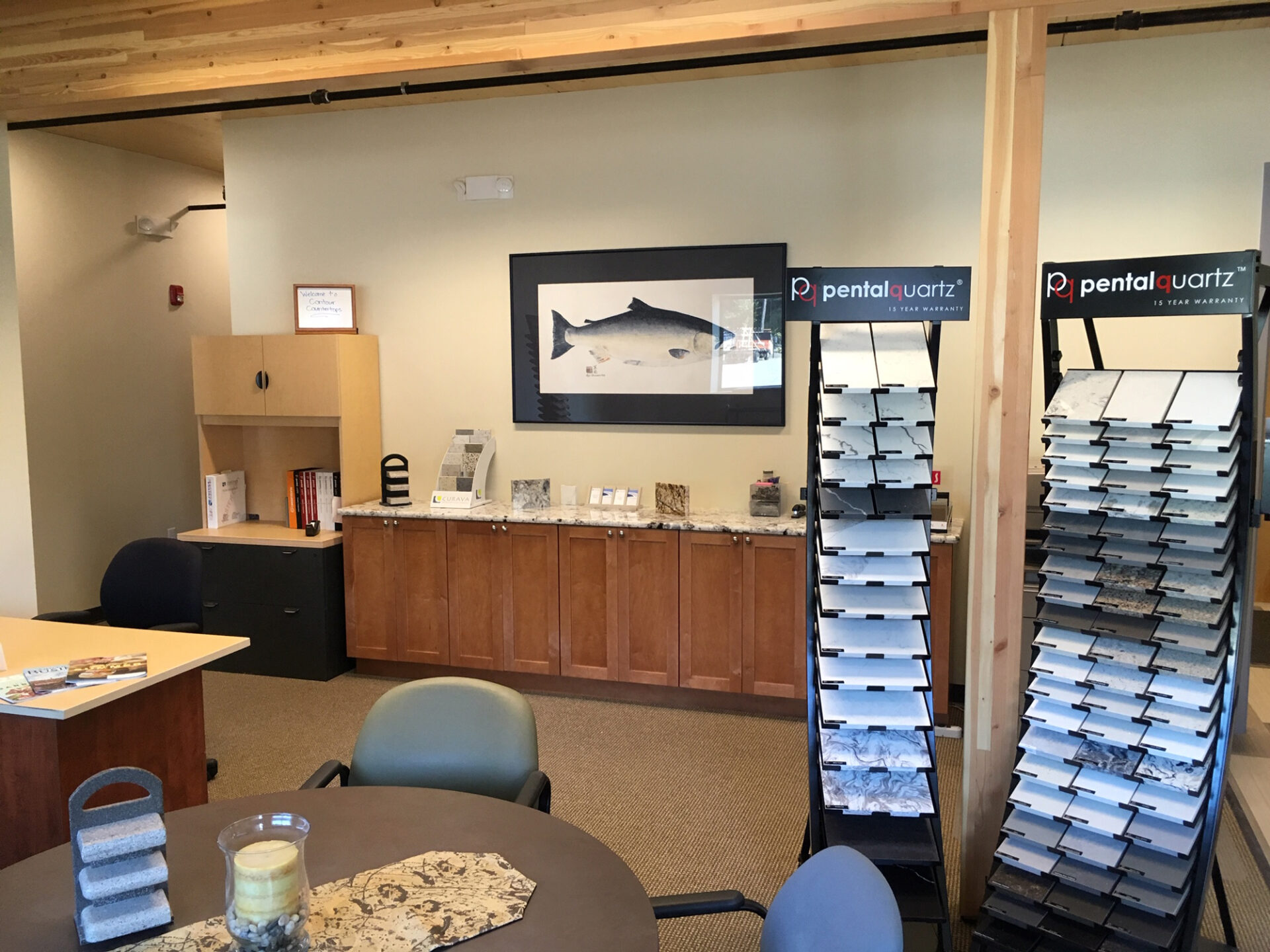 A room with tables and chairs, a picture of a fish on the wall.